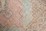 Textured distressed pile of vintage Turkish Oushak rug, blush pink, powder blue geometric patterns.