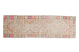 Distressed Oushak runner rug with faded triple medallion, featuring muted rust, pink, and ivory tones.