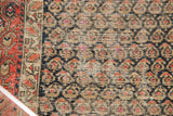 Antique Hamadan rug's field-to-border transition, featuring brick red, navy boteh paisley motifs.