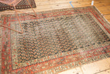 Antique Persian Hamadan rug corner detailing a brick red main border and navy boteh field.