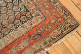 Antique Hamadan rug corner, brick red border and dark navy field with detailed boteh motifs.
