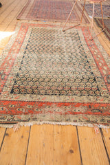 Hand-knotted fringe and brick red stylized boteh main border detail of an antique Hamadan rug.