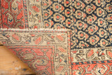 Folded corner of antique Persian Hamadan rug showing hand-knotted foundation and boteh pattern.