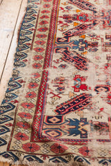Antique Seichor rug's reciprocating wave motif border on rare ivory ground, showing wear.