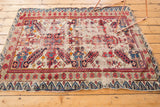 Antique Seichor rug's lower corner, with a distinct reciprocating wave border in navy and blush.