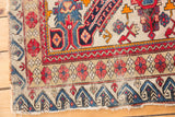 Antique Seichor rug corner showcasing the reciprocating wave motif and blush floral borders.