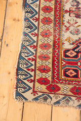 Antique Seichor rug's blue wave pattern border with red stylized floral motifs.