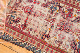 Antique Seichor rug's reciprocating wave border, geometric field motifs, and rich blush on ivory.