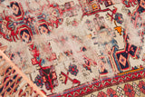 Reciprocating wave motif border in red, navy, and sky blue on an antique Seichor rug.