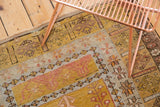 Vintage Turkish Melas hand-knotted detail with germinating plant motifs in saffron, terracotta, and platinum.