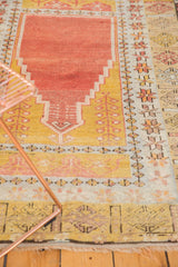 Corner of vintage hand-knotted Turkish Melas rug with softened palette and fringe.