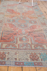 Distressed Oushak runner border featuring hook-and-latch motifs in terra cotta, slate blue, and ivory.
