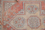 Distressed Oushak runner texture with hook-and-latch motifs, terra cotta, beige, slate blue.
