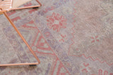 Worn pile and abrash on a distressed vintage Oushak rug in mauve and terra cotta.