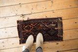 Antique Kurdish fragment rug with dark navy, teal, and madder red diamond and vine motifs.