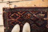 Antique Kurdish fragment rug with deep navy, teal, madder root diamond patterns and short fringe.