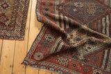 Antique Qashqai rug's intricate geometric weave, revealing nuanced colors and storied texture.