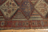 Antique Qashqai rug's intricate geometric border in chestnut, wine, and ivory with light tatter.