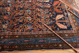 Ornate border and intricate vinery patterns of Hamadan rug in navy, rust, blush tones.