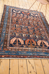 Vintage Hamadan rug corner, showing intricate navy blue border and white fringe.