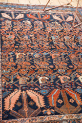 Serrated leaf motif with intricate vinery in navy blue, rust, and blush on a vintage Hamadan rug.