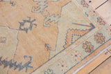 Faded seafoam green border and serrated geometric motifs on a distressed vintage Oushak rug.