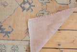 Distressed Oushak runner's textured pile, beige, blue, green tones, light foundation, and short fringe.
