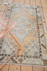 Vintage distressed Oushak rug runner corner with serrated leaf border and fringe.