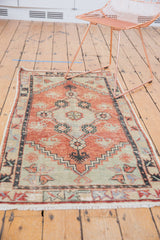 Distressed Oushak rug with floral medallion, stepped spandrels, pale cherry red, seafoam green.