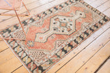 Distressed hand-knotted Oushak runner edge, featuring charcoal border, cinnabar field, and intact selvage.