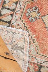 Hand-knotted vintage Oushak runner showing back foundation, original selvage, and distressed cinnabar pile.
