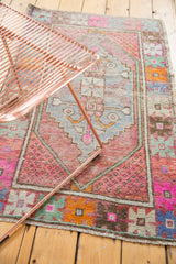 Distressed Oushak rug corner, vivid pink, orange, mint geometric border and fringe.
