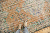 Worn vintage Distressed Oushak carpet with dusty apricot, faded blue, and exposed foundation underfoot.