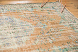 Distressed vintage Oushak carpet with faded apricot, beige, blue, green motifs, and visible foundation.