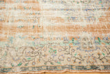 Distressed vintage Oushak rug: worn texture, visible foundation, faded apricot and blue.