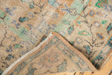 Distressed vintage Oushak rug corner reveals worn pile, exposed foundation, muted beige, mint, blue patterns.
