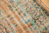 Distressed Oushak carpet revealing worn apricot pile, visible foundation, and muted mint motifs.