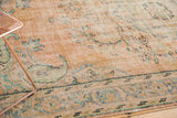 Distressed apricot Oushak rug, worn pile revealing knot heads, with mint green patterns.
