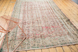 Faded floral patterns and soft distressed pile of a vintage Oushak rug.