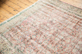Distressed Oushak rug detail showing faded dusty rose floral field with even wear to knot heads.