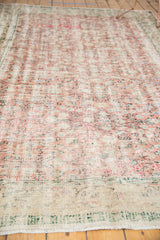 Distressed Oushak carpet end with fringe and visible worn knot heads.