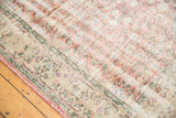 Secured side edge of distressed Oushak rug, showing muted rose, ivory, mint florals.