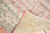 Distressed Oushak carpet's worn pile texture, white fringe, and hand-knotted reverse.