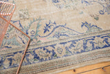 Distressed Oushak rug's ornate border with faded blue and green motifs.