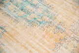 Distressed Oushak carpet detail: faded aqua, peach, ivory tones, and even wear revealing foundation.