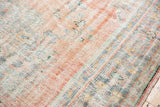 Distressed pile of the Oushak carpet, with faded blush, antique ivory, and slate blue tones.