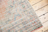 Distressed Oushak rug corner texture, showing faded red, ivory, and slate blue foundation.