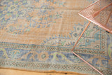Faded peach, royal blue, and mint floral patterns on distressed vintage Oushak rug.