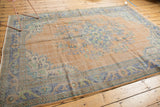 Faded royal blue border and distressed peach field with worn knot heads, floral patterns.