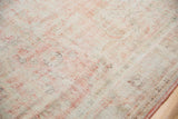 Distressed Oushak rug surface with cotton white, blush rose tones, and visible knot heads.